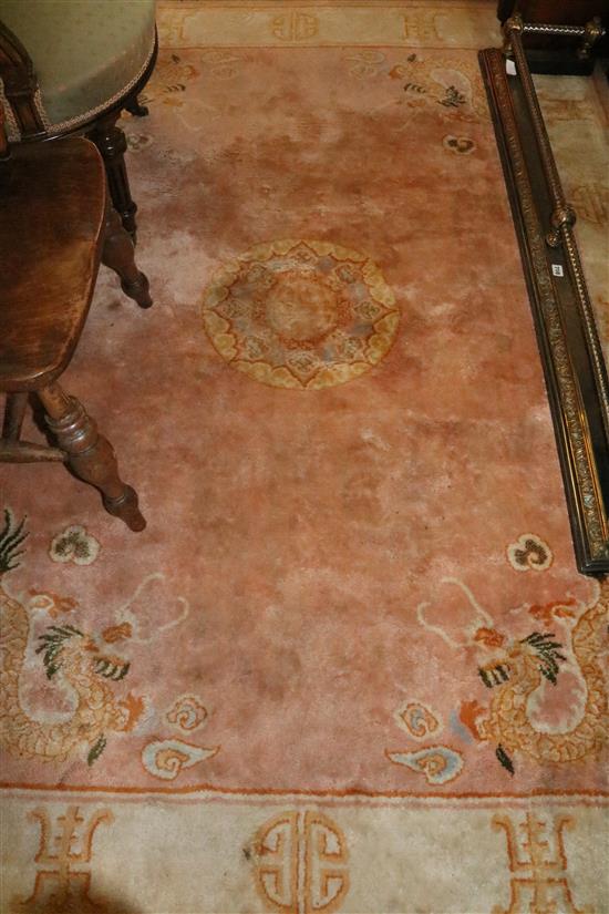 A Chinese pink ground rug(-)